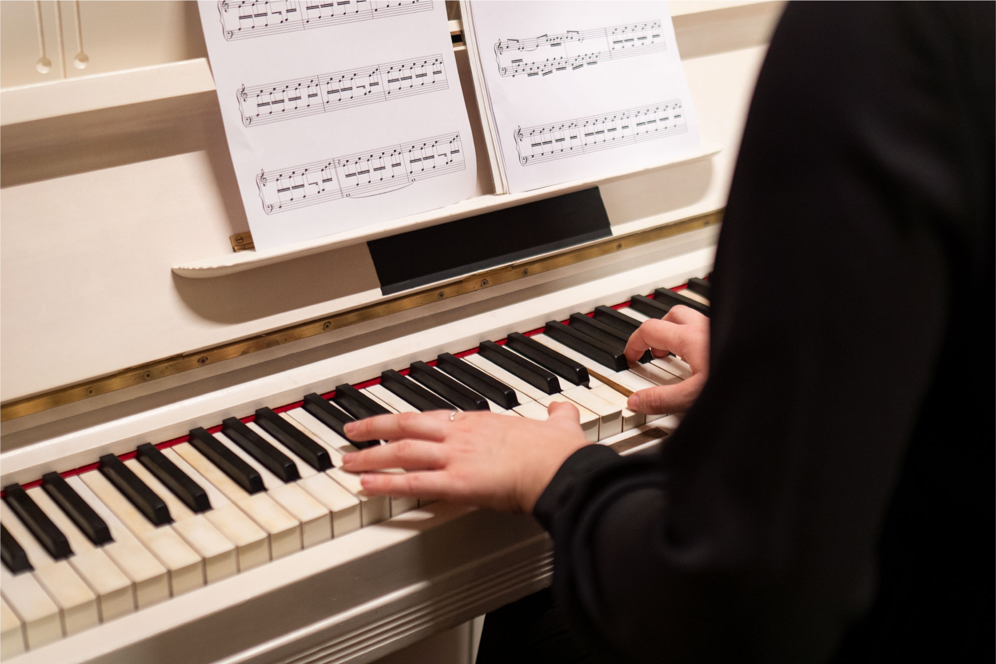 Joueur de piano concentré sur une partition musicale