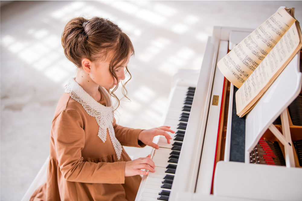 Jeune pianiste concentrée sur sa partition mélodivers